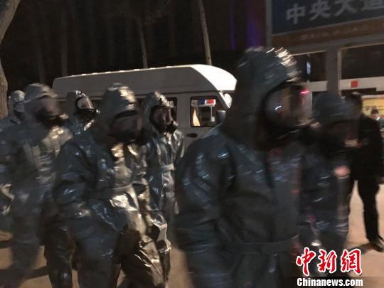 十几名身着防护服的人员头戴面具进入事发地。　胡健 摄